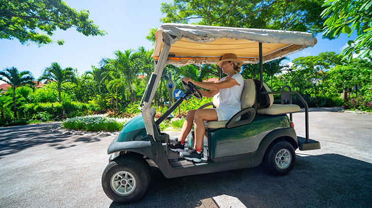 A golfer in a golf cart considering the need for golf cart insurance.