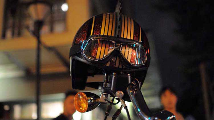 A motorcycle helmet rests on a cycle’s handlebar.