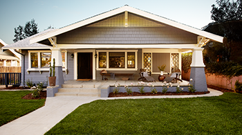 A sidewalk leads up to an one-story home with a front porch.