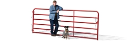 Profile of a man leaning against a red fence with his dog sitting next to him.