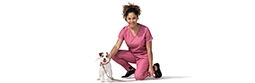 A female vet kneels next to a dog.