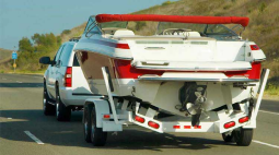 A SUV pulls a boat on a trailer.