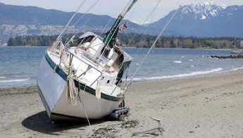 A beached sailboat rests on its side.