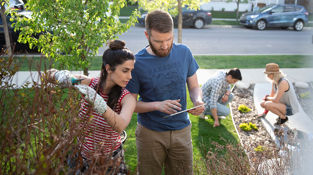 Scanning their ipad outside, a couple review their condo maintenance checklist.