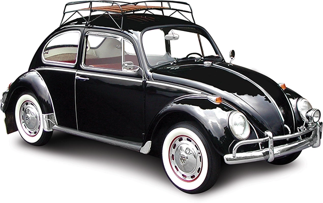 A classic black VW bug with a rack on the roof and whitewalls on the tires.