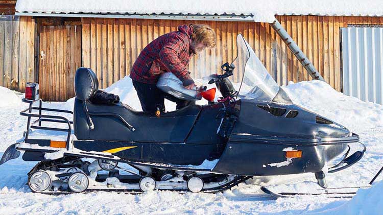 A man unloads his snowmobile.