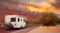 A RV drives into the sunset.