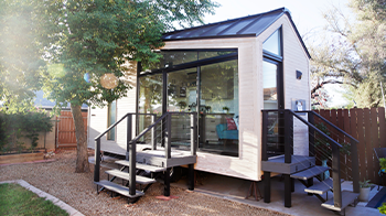 Tall glass windows front a small home