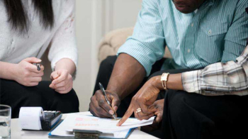 A tight shot of hands signing a rental lease.