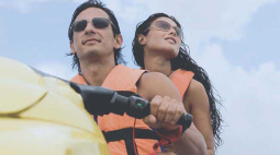 With orange life vests, a couple enjoy a day on a jet ski.